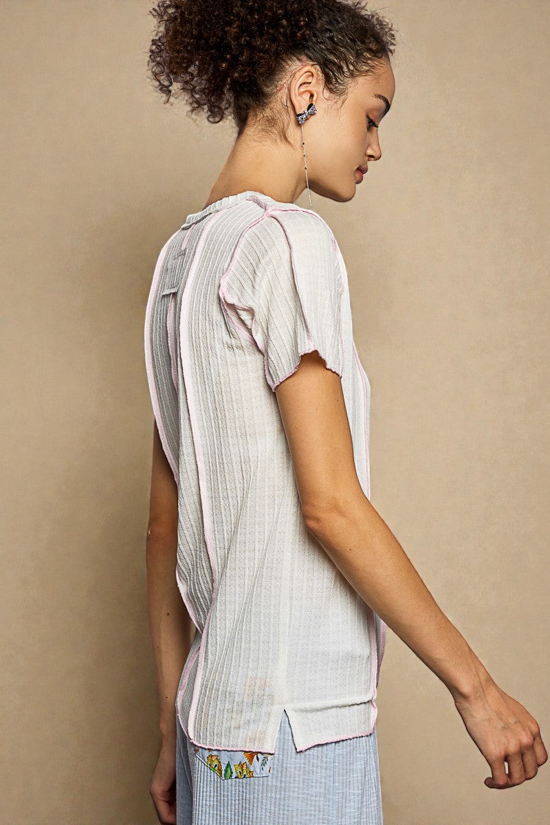 Woman wearing a light-colored outfit with a textured pattern against a beige background