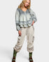 Woman wearing a layered outfit with a top and cargo pants on a white background