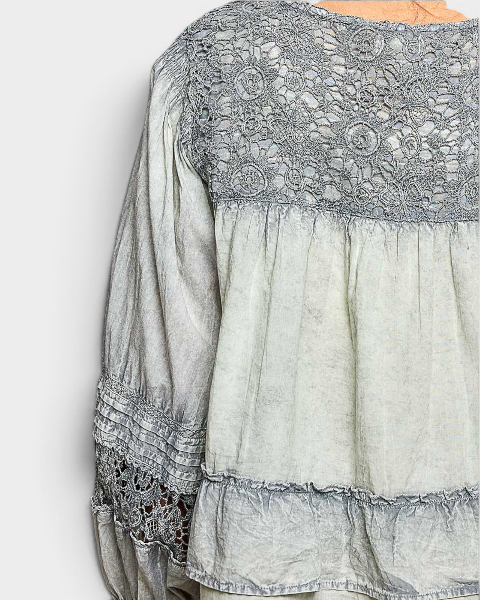 Light gray blouse with lace details on a white background