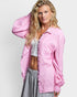 Woman wearing a pink shirt over a white top and gray pants on a light gray background