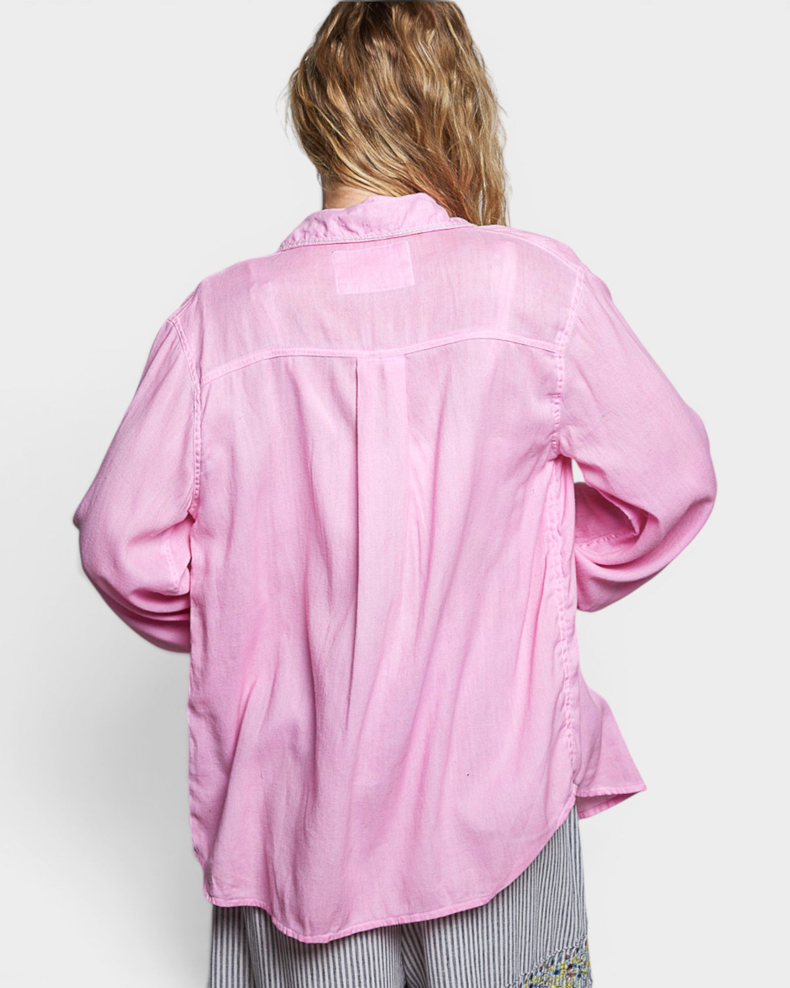Person wearing a pink shirt on a white background