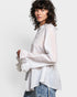 Woman wearing a light-colored blouse with lace details on a white background