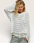 Woman wearing a white textured sweater with a plain background