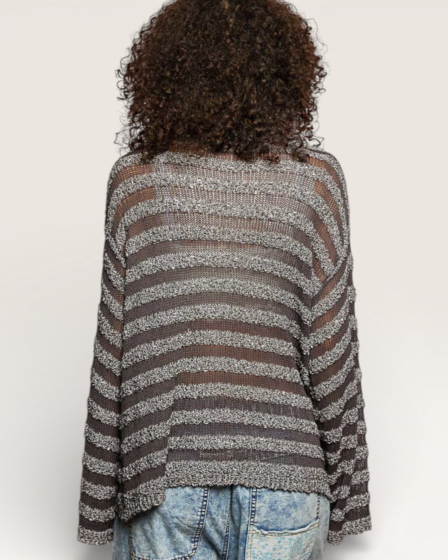 Person wearing a striped sweater with a neutral background