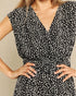 Black and white patterned dress with a belt on a neutral background