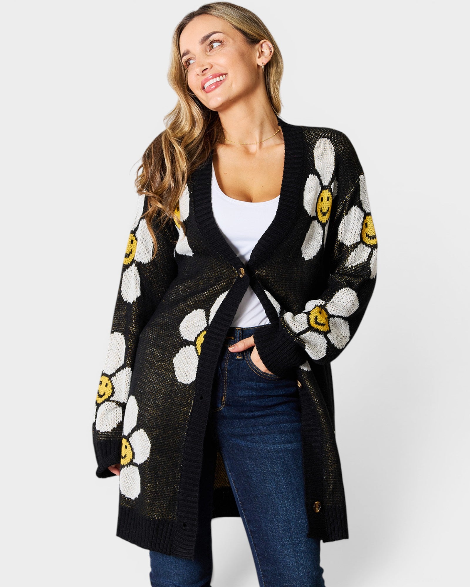 Woman wearing a black cardigan with white floral patterns on a white background