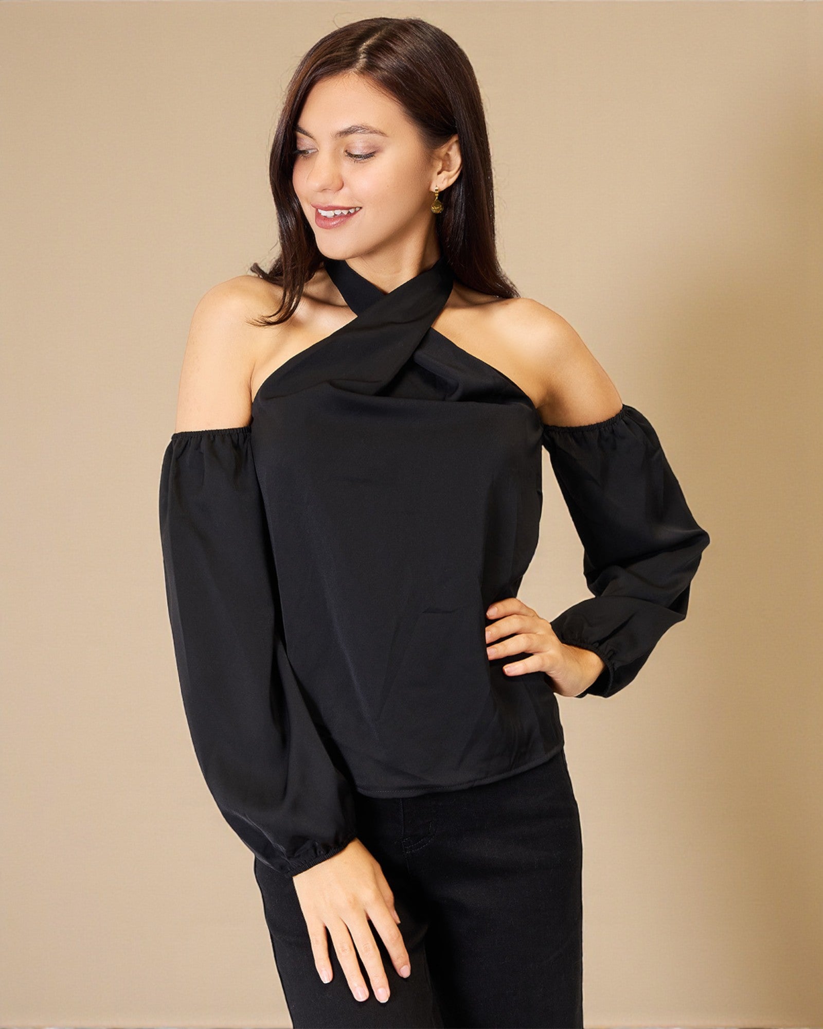 Woman wearing a black off-shoulder top against a beige background