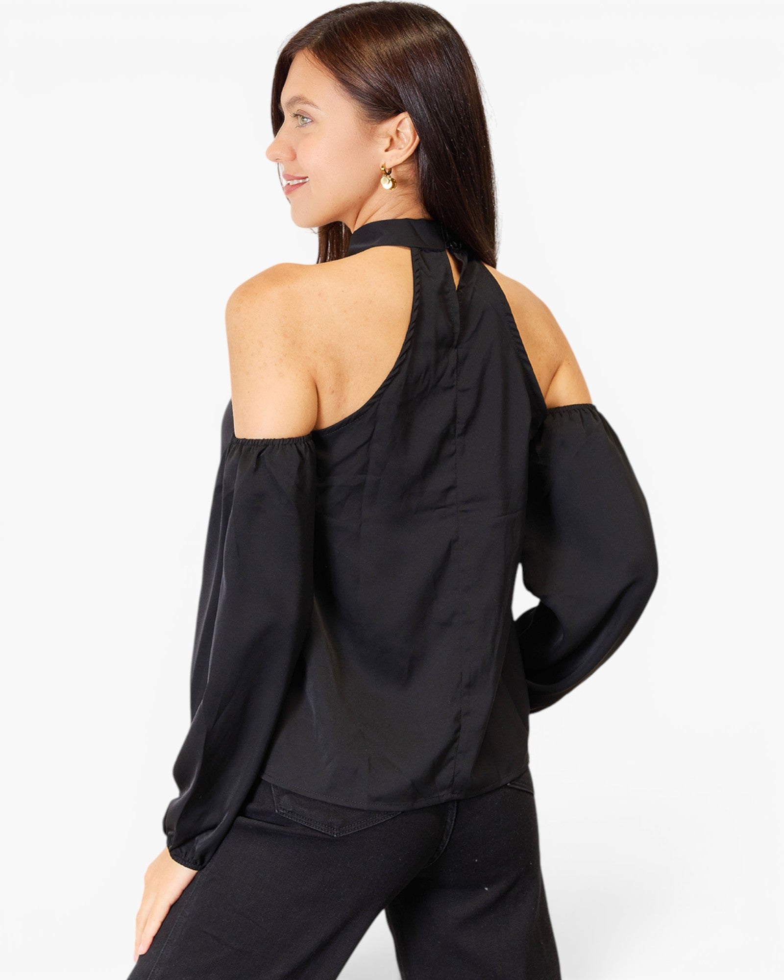 A woman shown from the back wearing a black cold-shoulder long-sleeve top with a high neck and cutout shoulders, paired with black pants, against a plain white studio background.