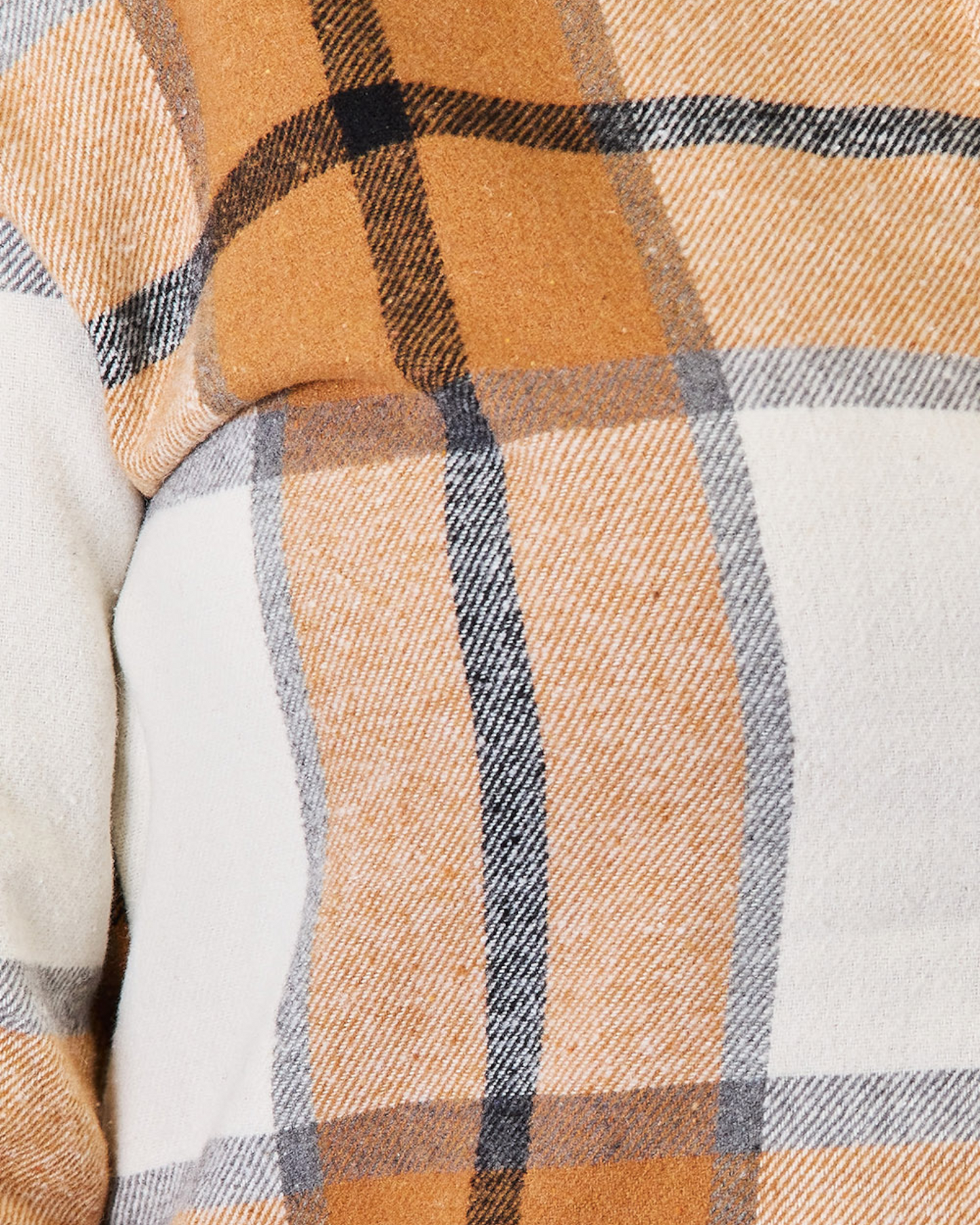 Close-up of a plaid fabric with brown, blue, and white colors.