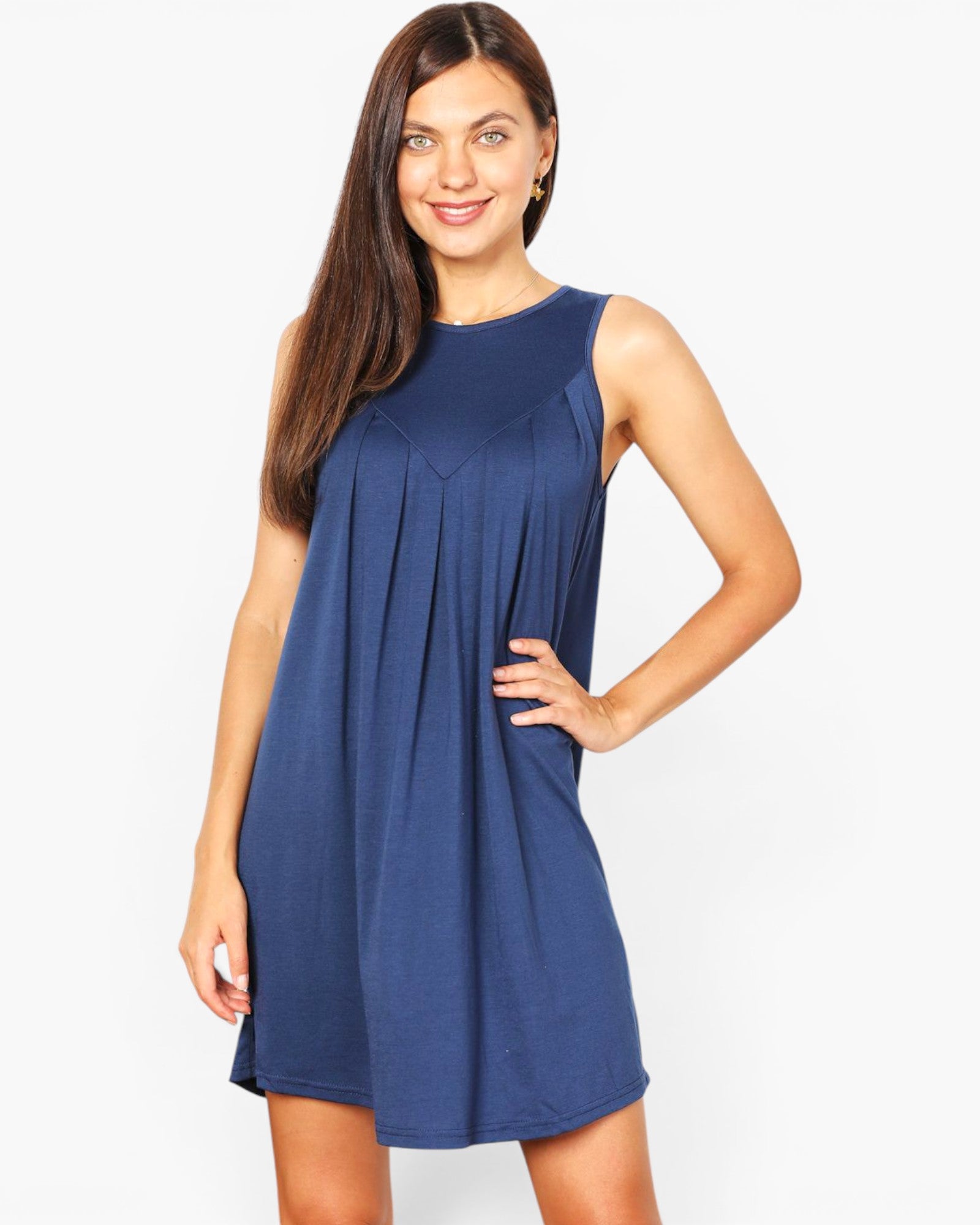 A woman modeling a sleeveless, scoop-neck shift dress in a solid medium blue color, standing against a light gray studio background.