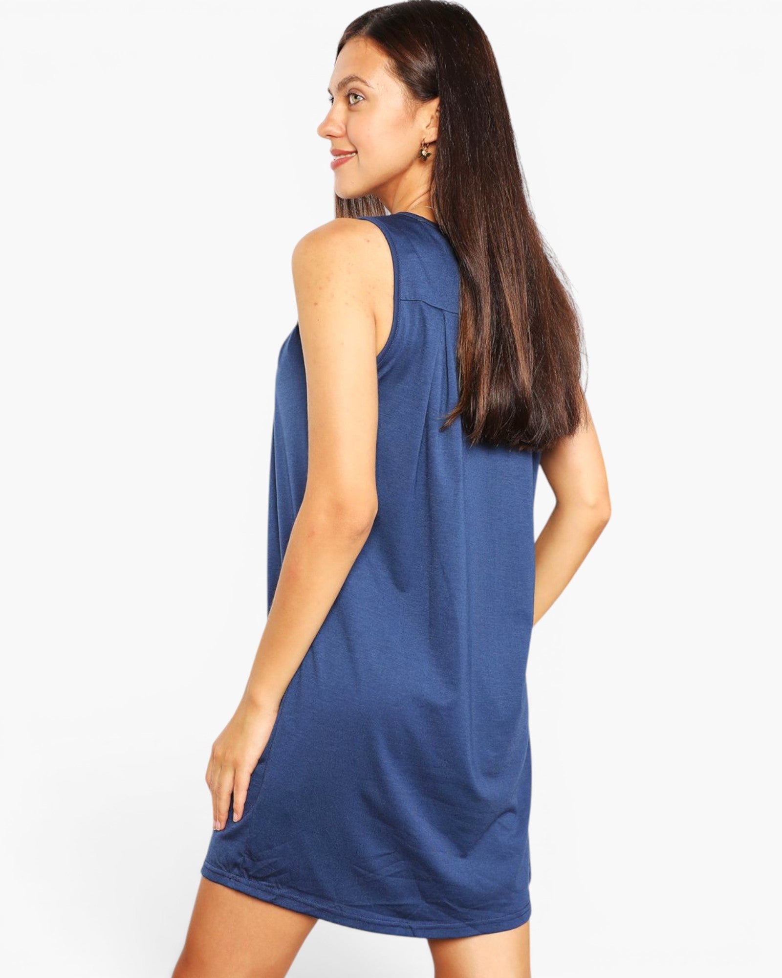 A woman modeling a sleeveless blue shift dress, shown from a three-quarter back angle against a plain white studio background.