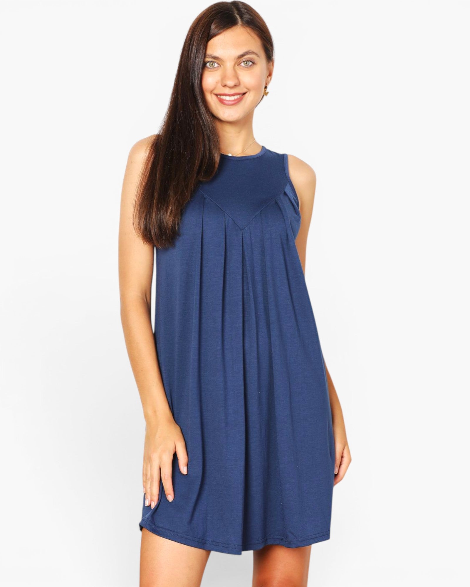 A woman modeling a sleeveless, high-neck, pleated mini dress in a solid navy blue color, set against a plain white studio background.