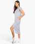 A woman modeling a light heather gray short-sleeve midi dress with side pockets, paired with white ankle boots, against a plain white studio background.