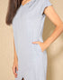 Woman wearing a light gray dress with a beige background