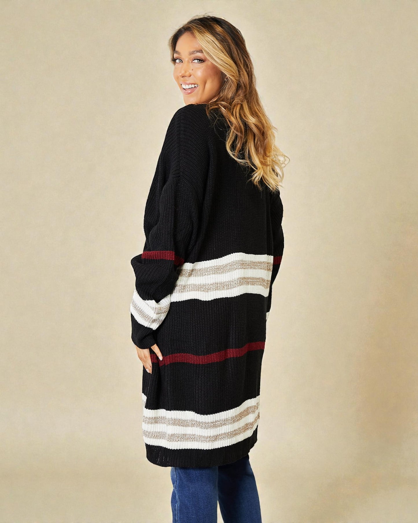 Woman wearing a black cardigan with horizontal stripes on a beige background
