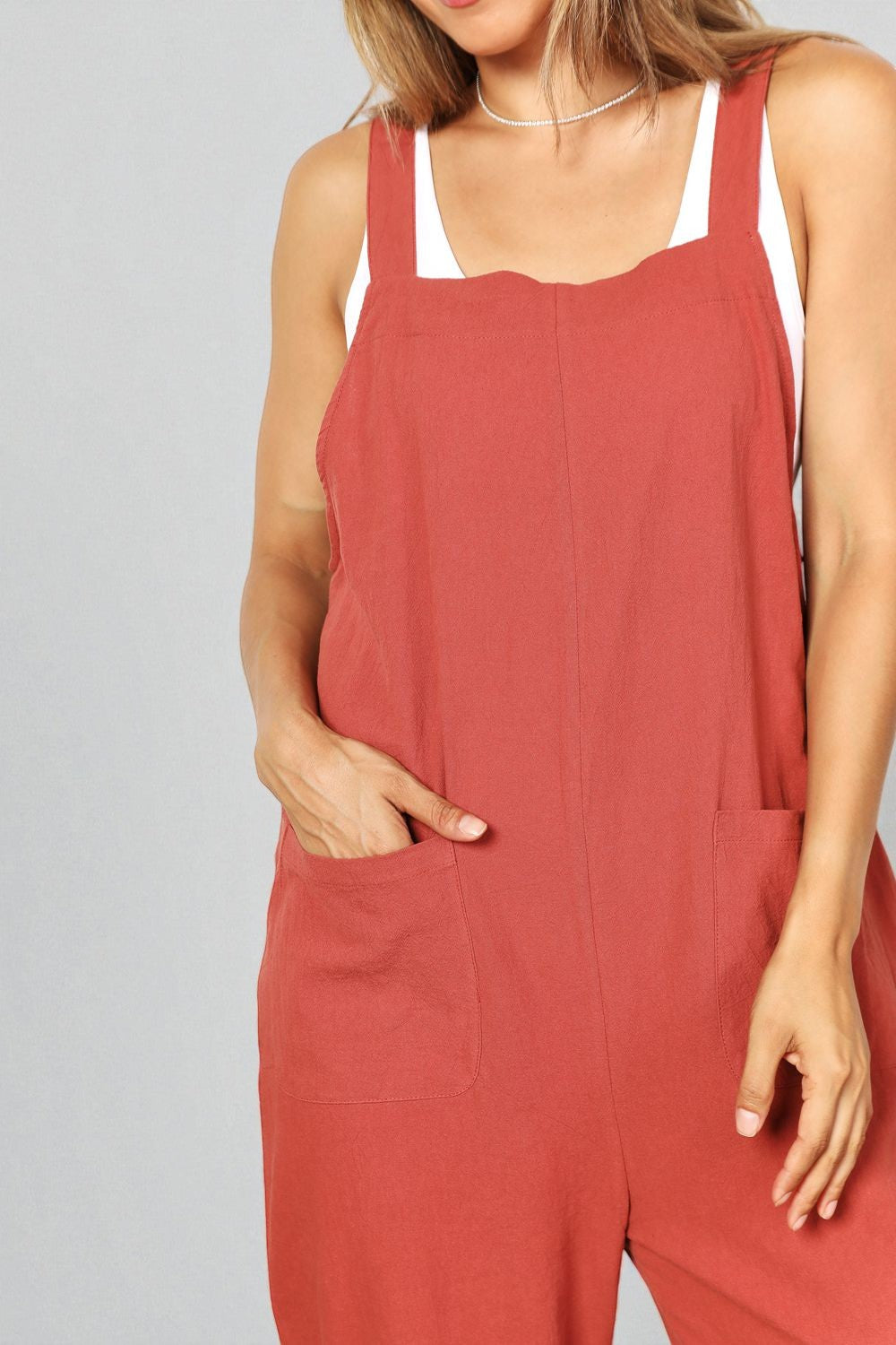 Person wearing a red jumpsuit against a gray background