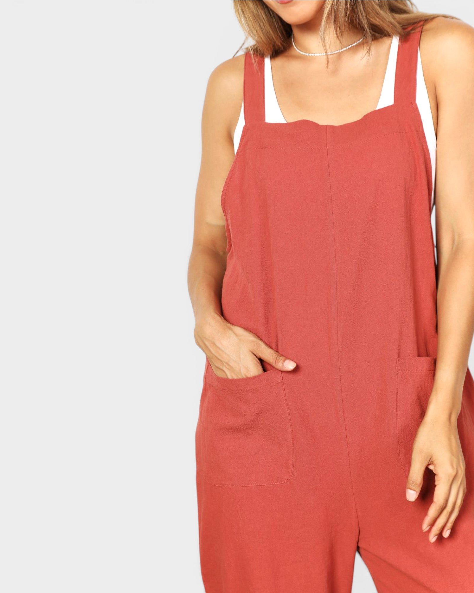 Person wearing a red jumpsuit on a plain background