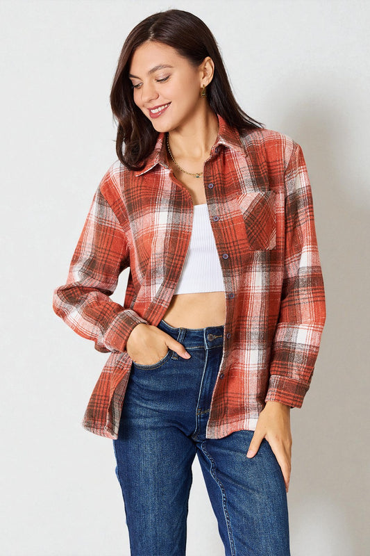 Woman wearing a red plaid shirt and blue jeans against a white background