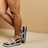Person wearing black and gray sandals on a beige background