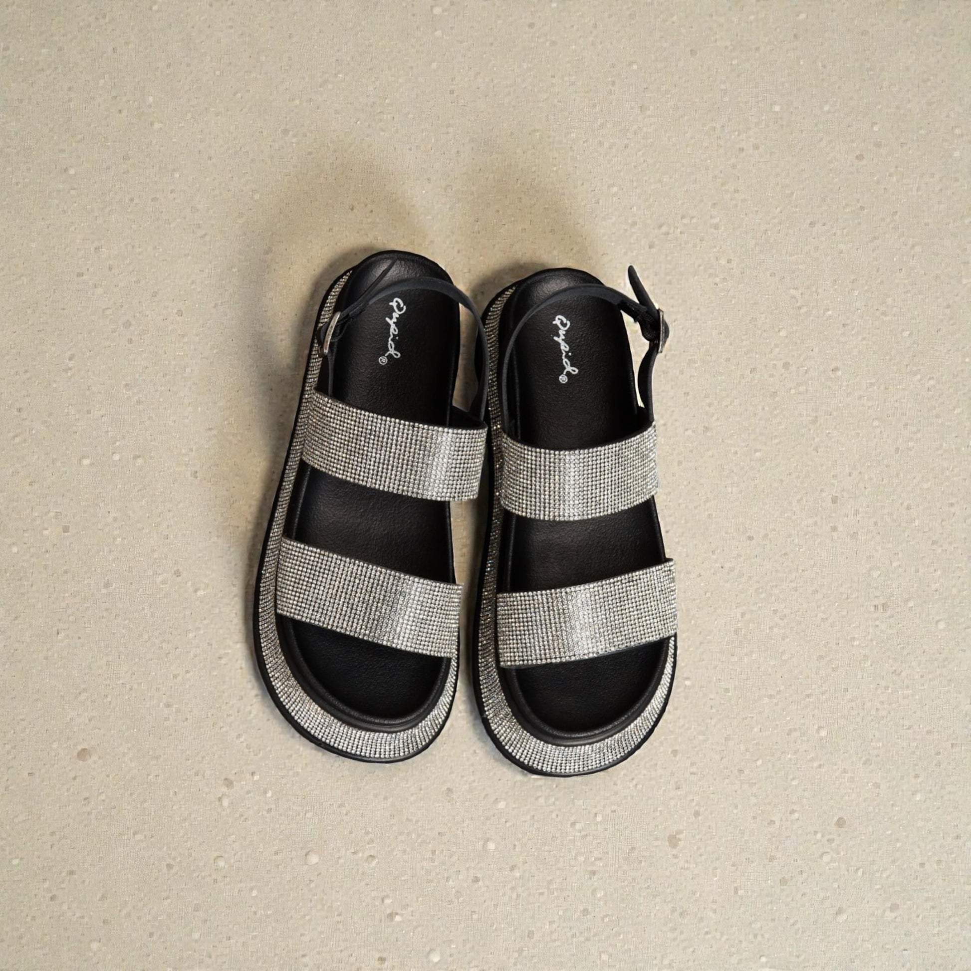 Black and gray sandals on a beige surface