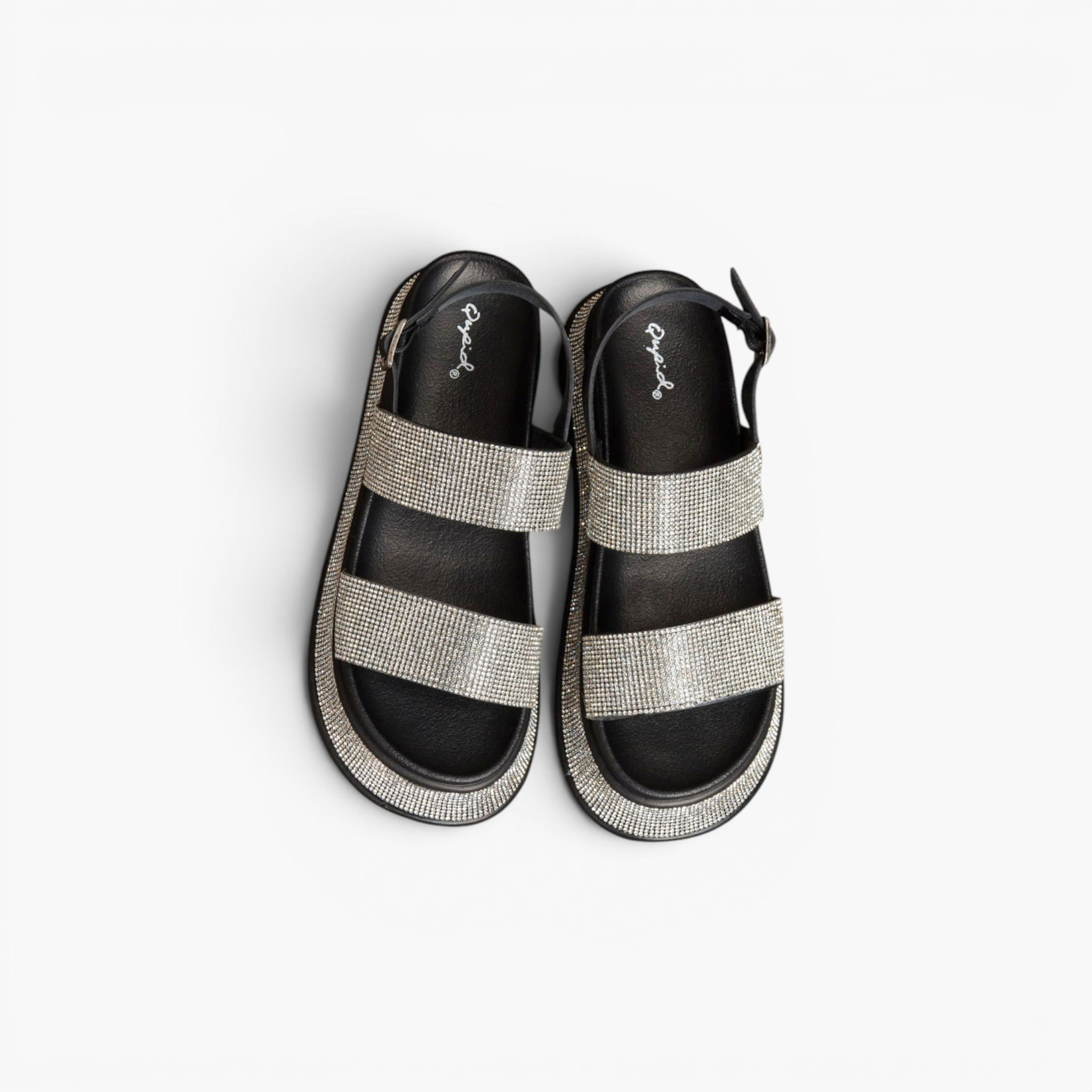 A pair of women's platform sandals with wide, textured silver glittery straps over a black footbed, shown from a top-down view on a white background.