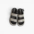 A pair of women's platform sandals with wide, textured silver glittery straps over a black footbed, shown from a top-down view on a white background.