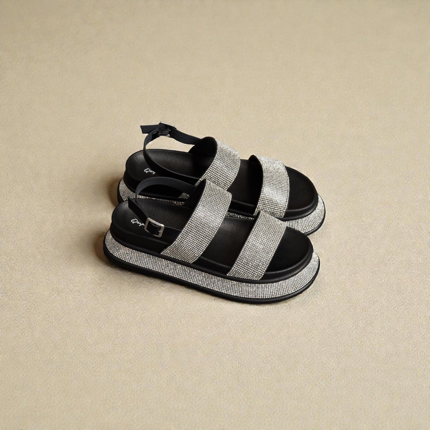 Black and gray sandals with platform sole on a beige background