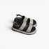 A pair of platform sandals with wide, sparkling silver glitter straps and black soles, displayed on a clean white background.