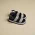 Black and gray sandals with platform sole on a beige background