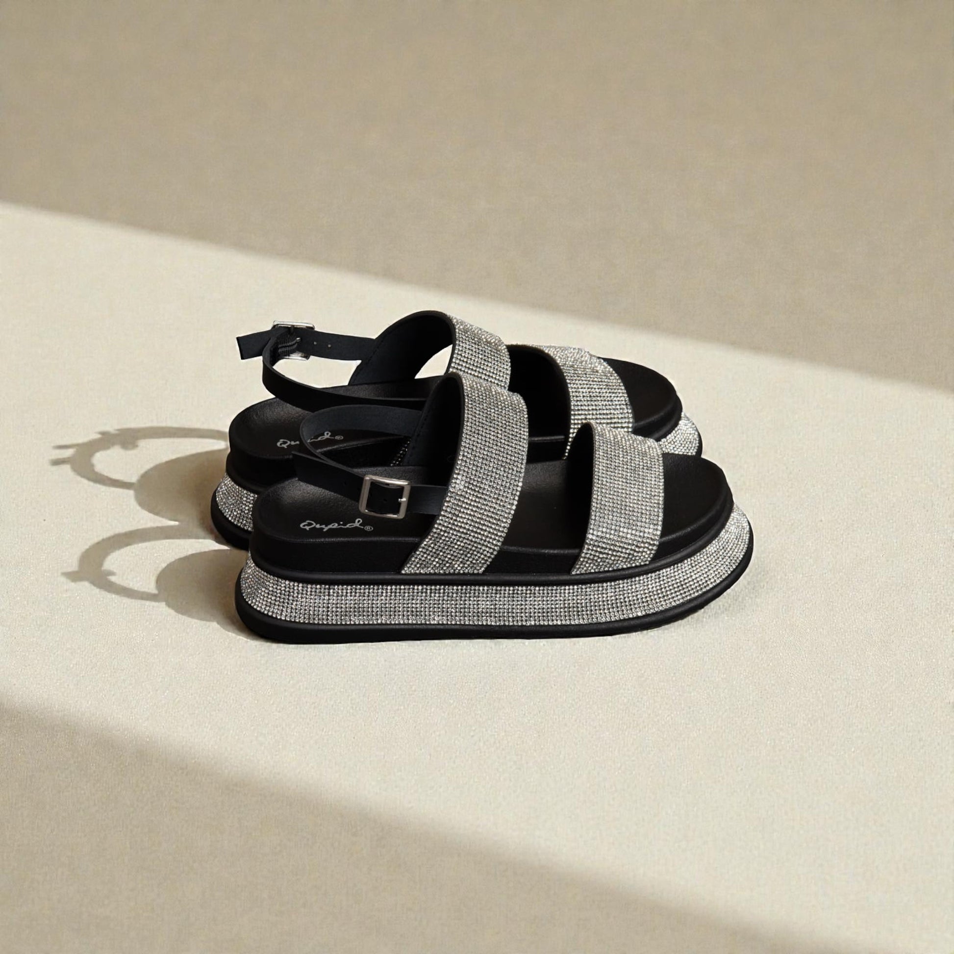 Black and gray sandals on a beige surface