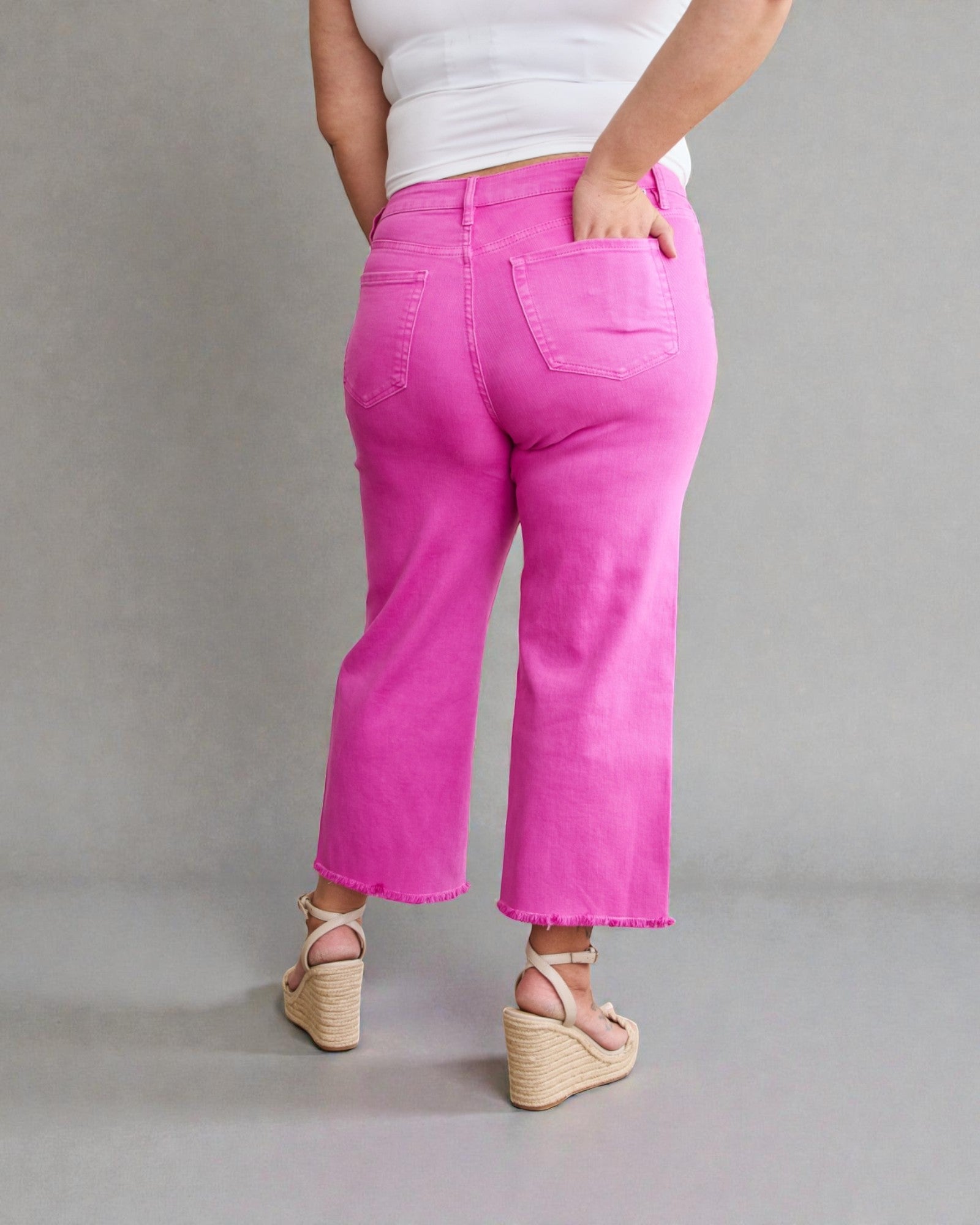 Person wearing bright pink pants on a plain background