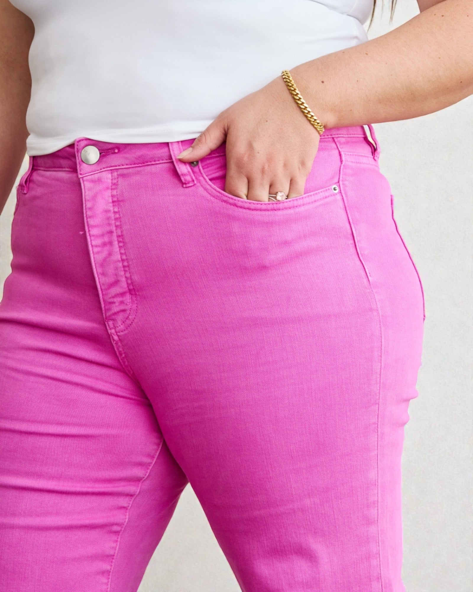 Person wearing bright pink jeans with a plain background