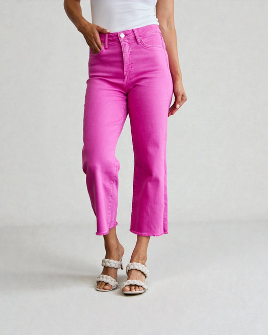 Person wearing bright pink jeans on a plain background