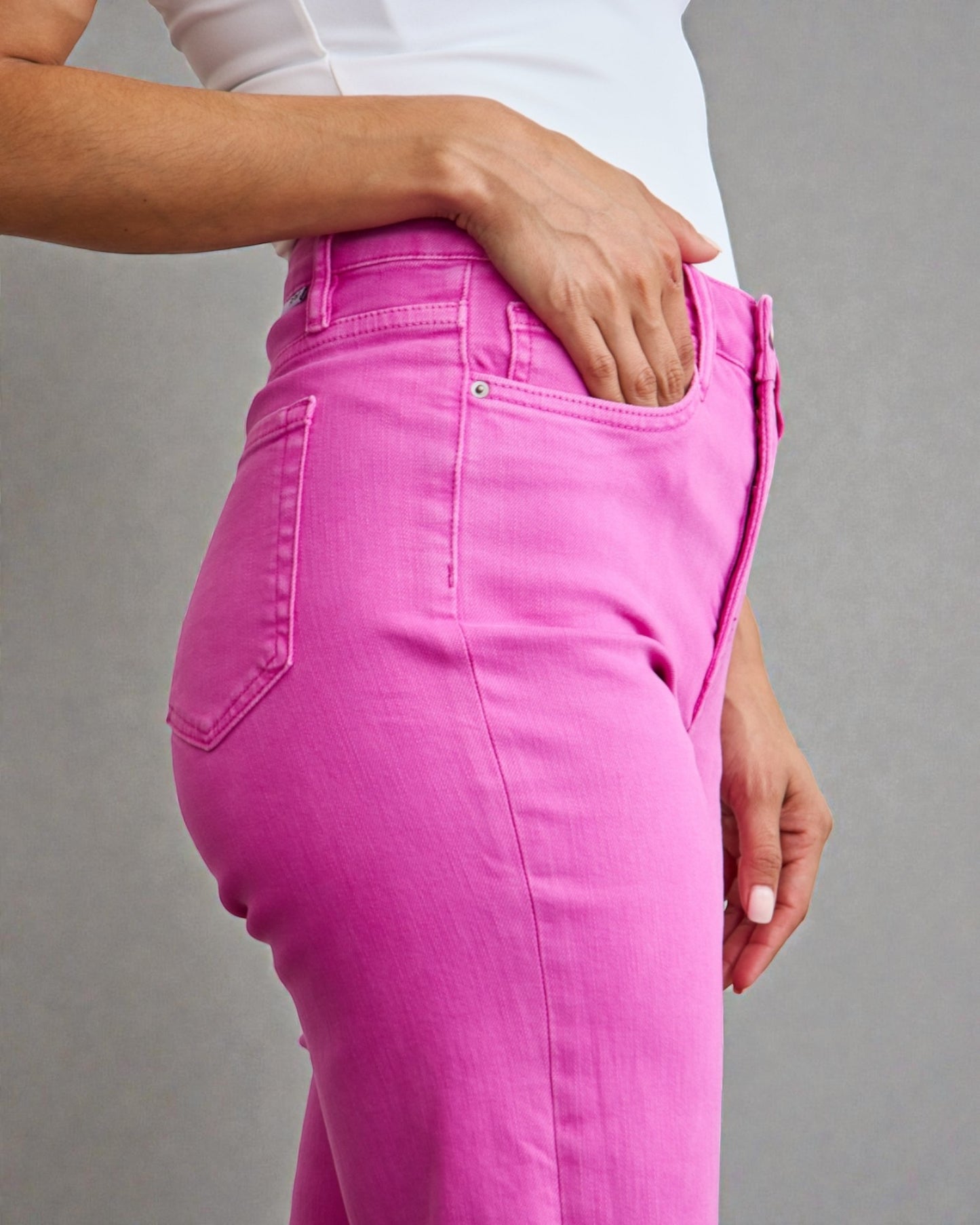 Person wearing bright pink pants on a gray background