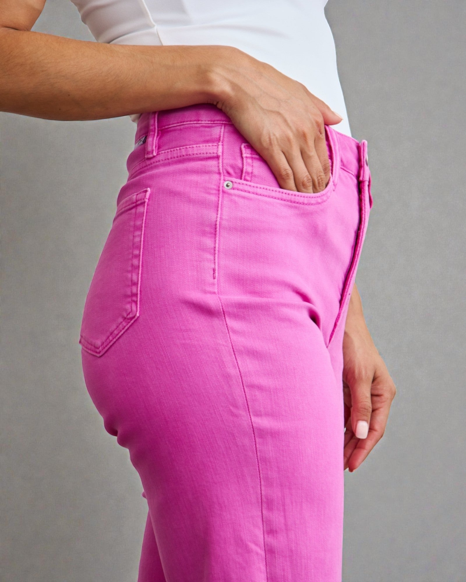 Person wearing bright pink pants on a gray background