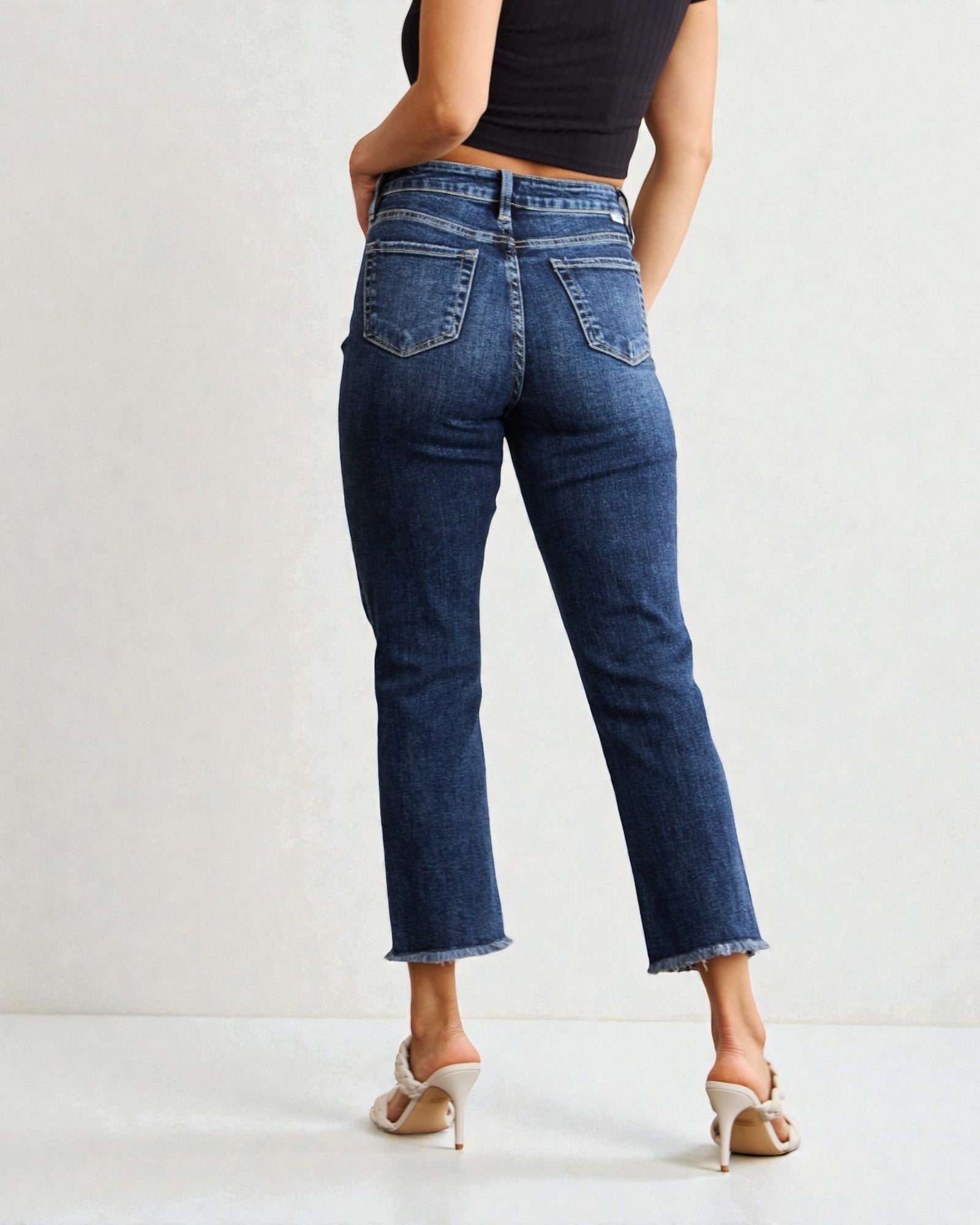 Jeans desgastados con cintura alta, dobladillo sin rematar y control de abdomen y lavado oscuro