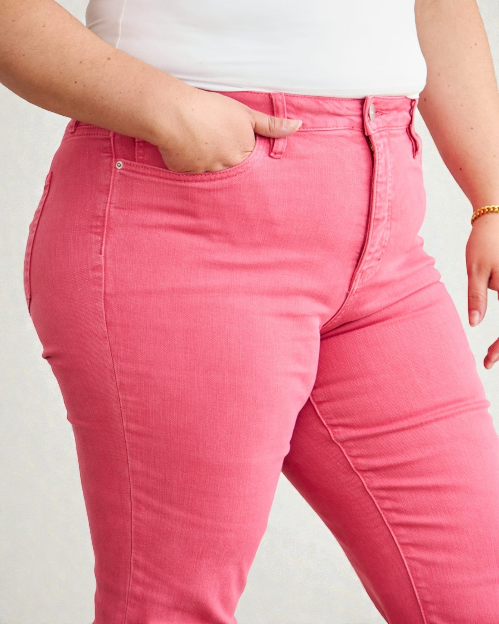 Person wearing bright pink jeans on a plain background