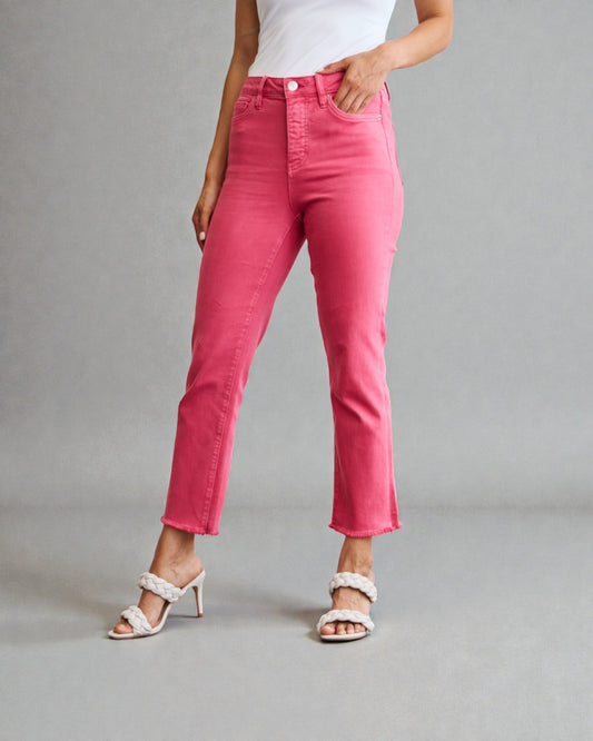 Person wearing bright pink jeans on a gray background
