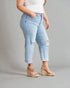 Person wearing light blue distressed jeans and beige sandals on a gray background