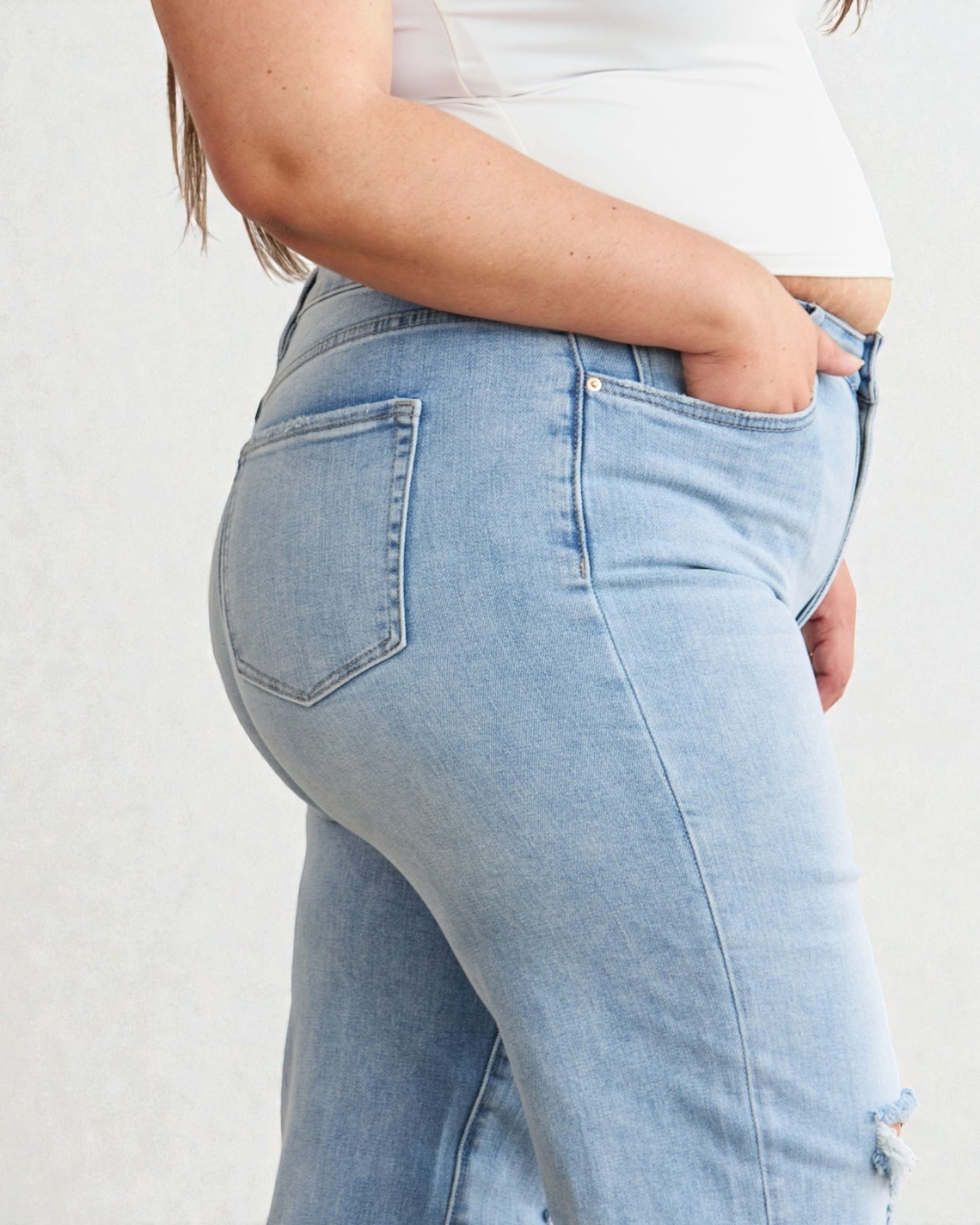 Light blue jeans worn by a person on a plain background