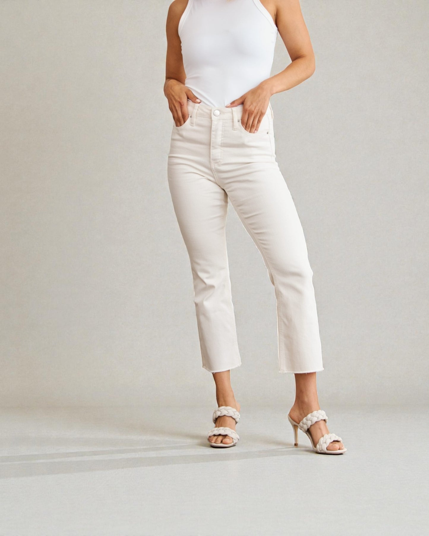 Person wearing white pants and a white top on a plain background