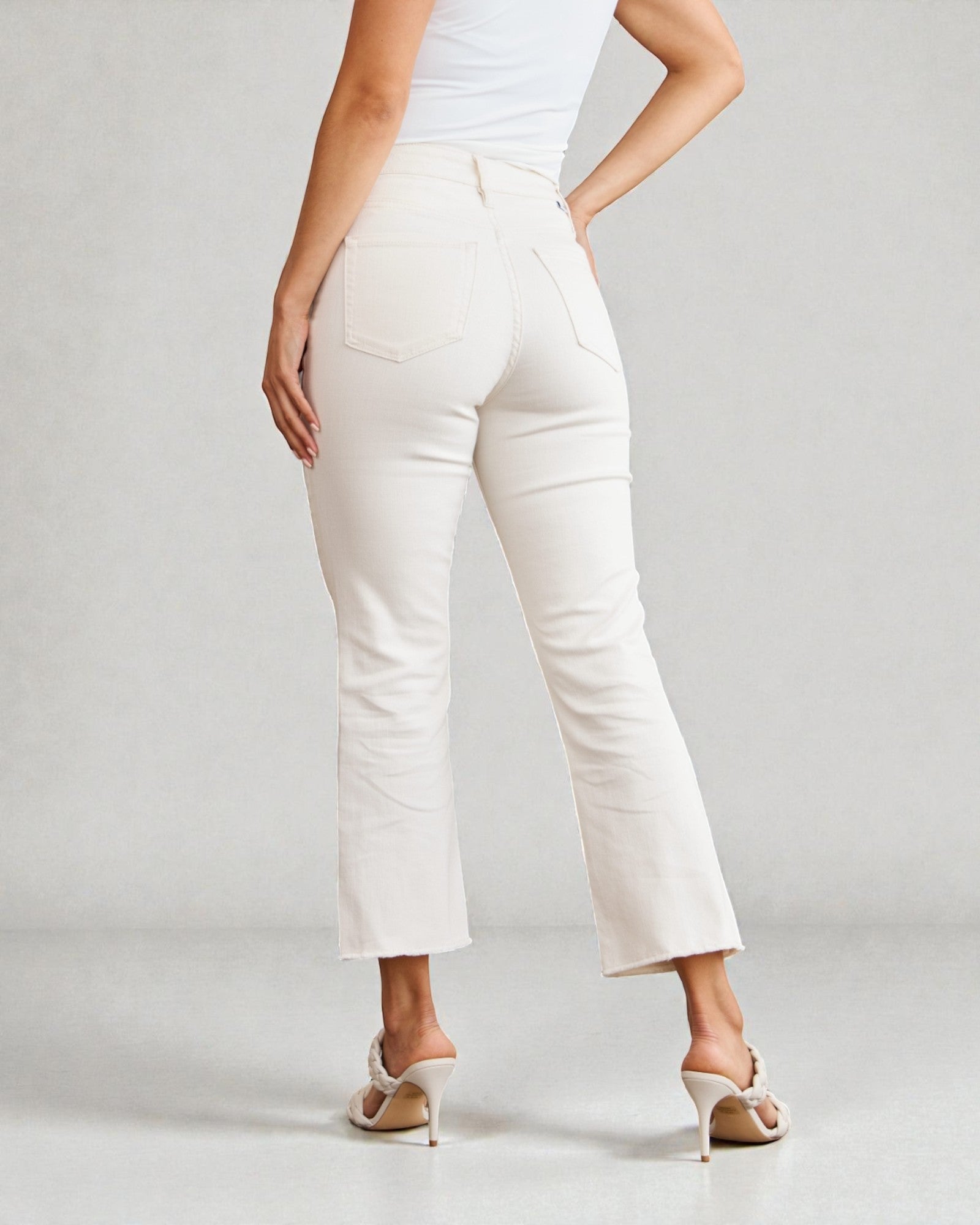 Person wearing white pants on a plain background