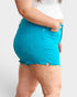 Shorts de mezclilla con cintura alta y dobladillo sin rematar que controlan el abdomen en verde azulado cristal