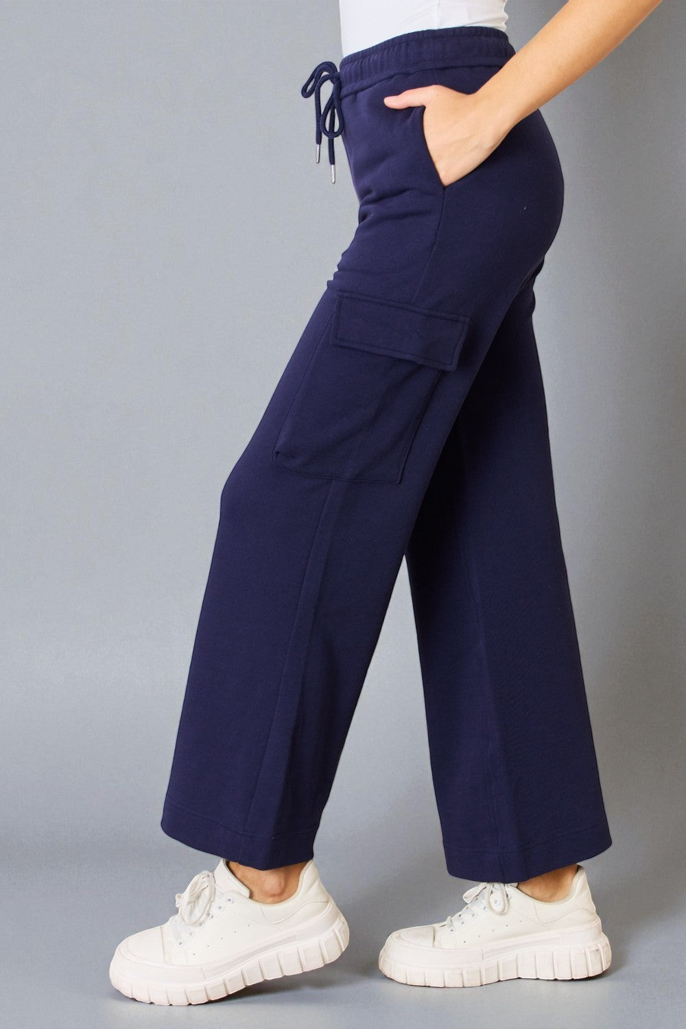 Navy blue wide-leg pants worn by a person on a gray background