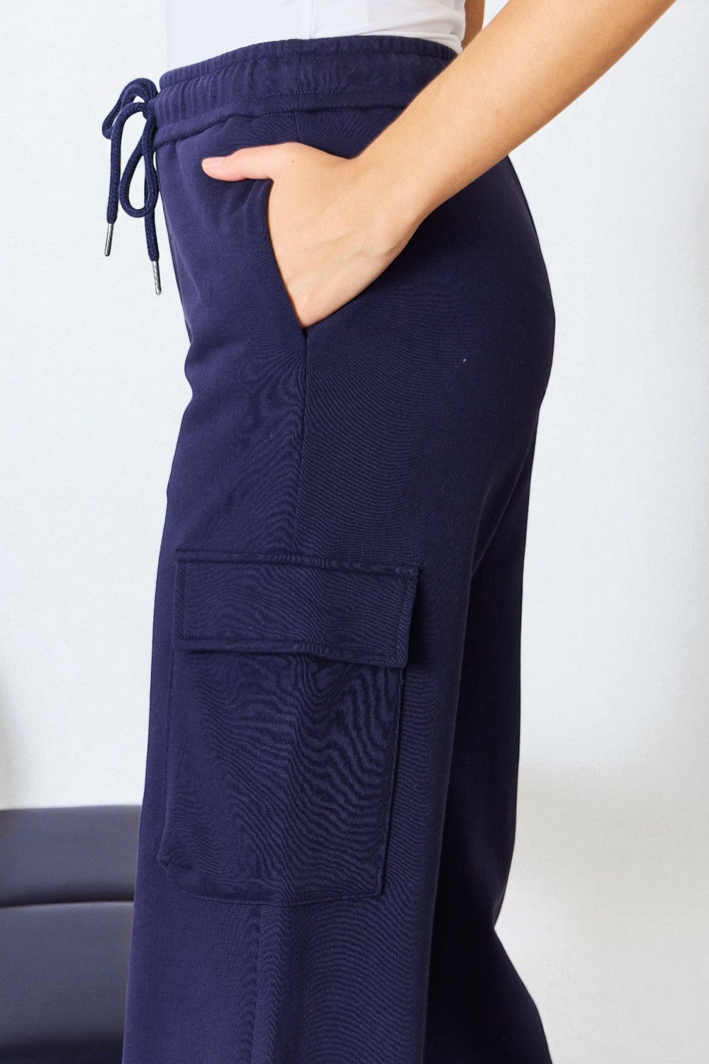 Navy blue cargo pants with a drawstring on a white background