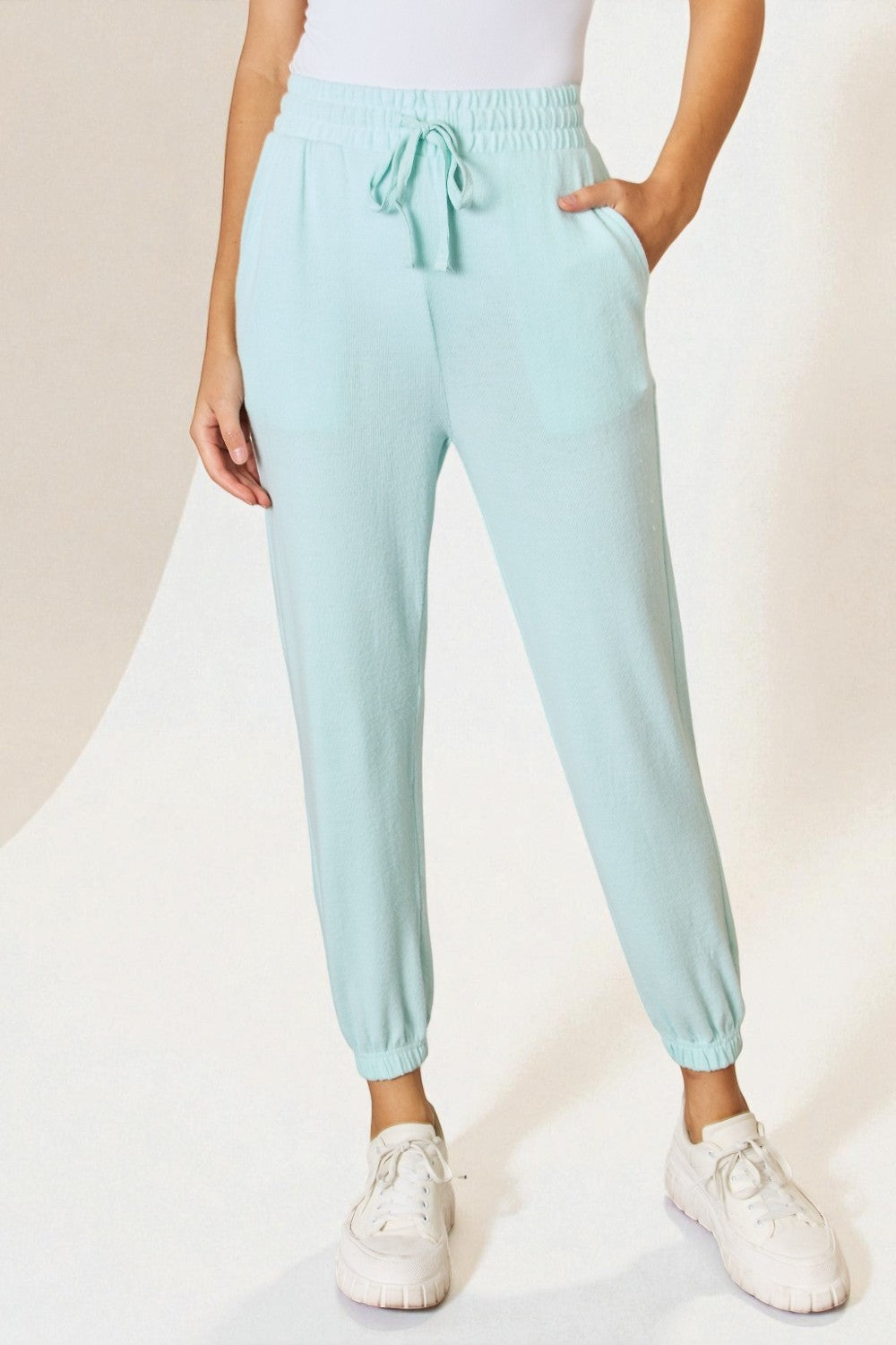 Light blue jogger pants worn by a person on a white background