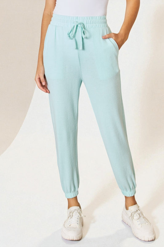 Light blue jogger pants worn by a person on a white background