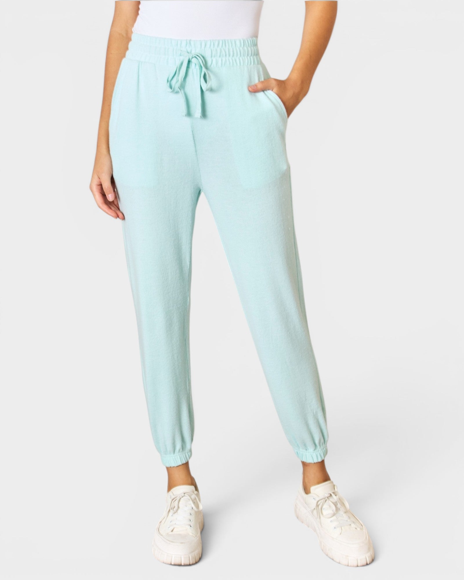 Light blue jogger pants worn by a person on a white background