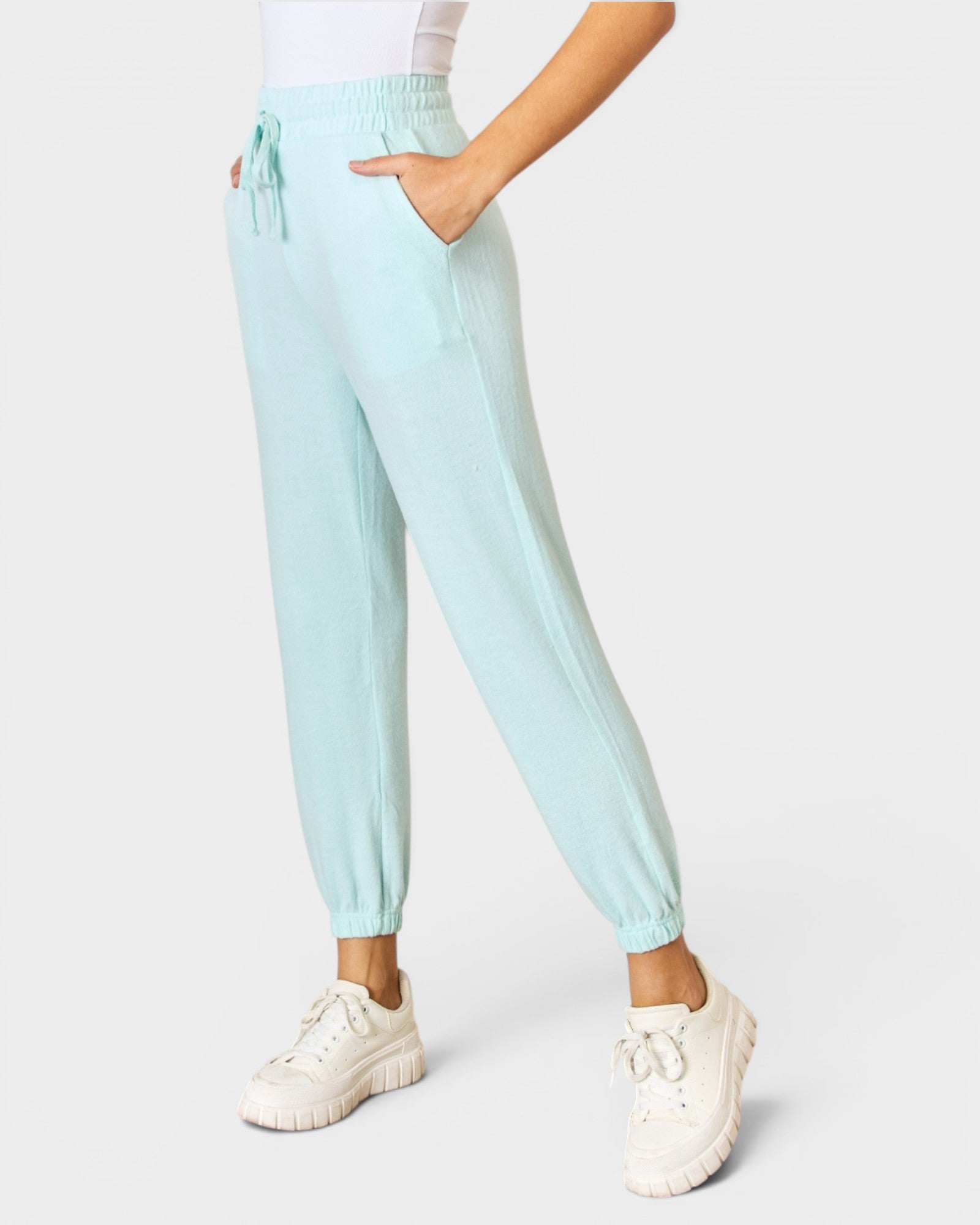 Light blue jogger pants worn by a person on a white background