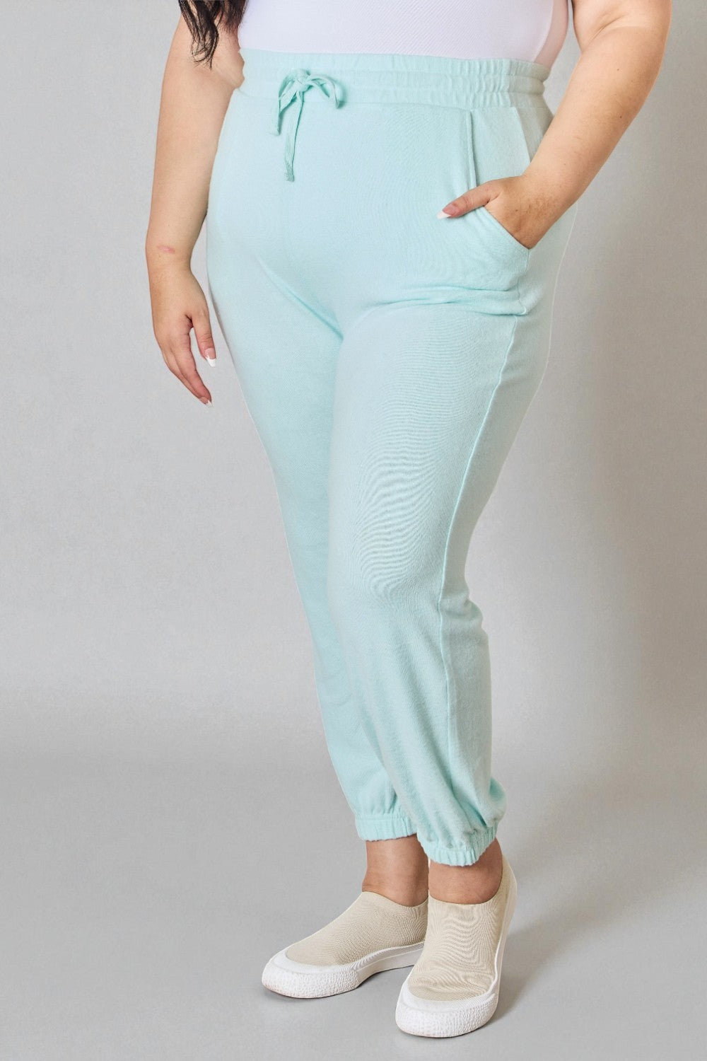 Person wearing light blue jogger pants on a plain background